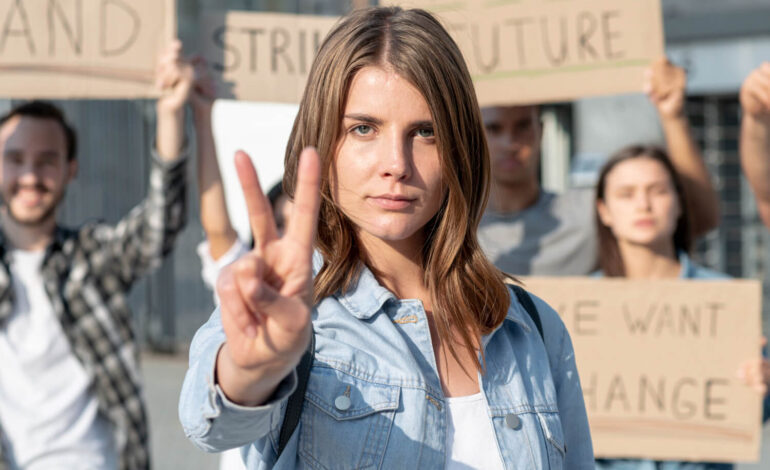 A girl smiling and pointing a victory sign, with playing cards in the background displaying words like 'Future' and 'Change,' symbolizing optimism and empowerment in the context of controversial topics.