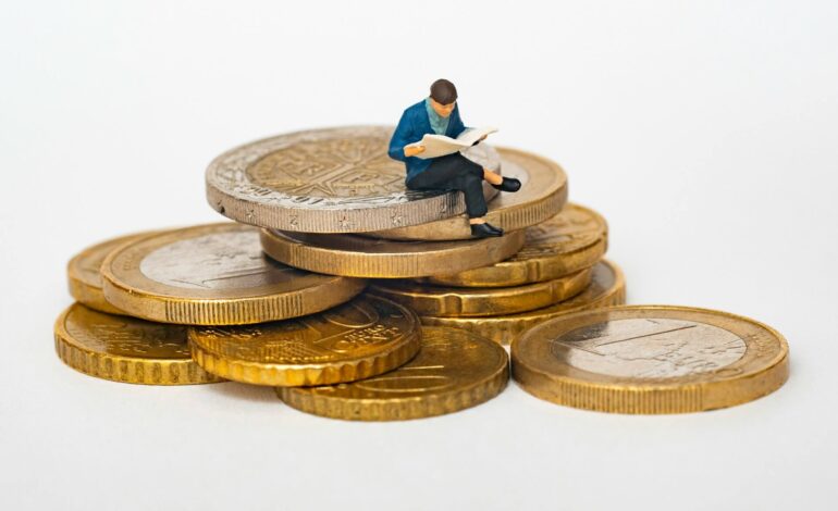 A cartoon illustration of a man sitting on a stack of gold coins, reading a document, symbolizing financial planning and economic trends.